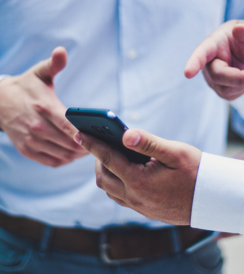 Dos personas revisando un teléfono móvil